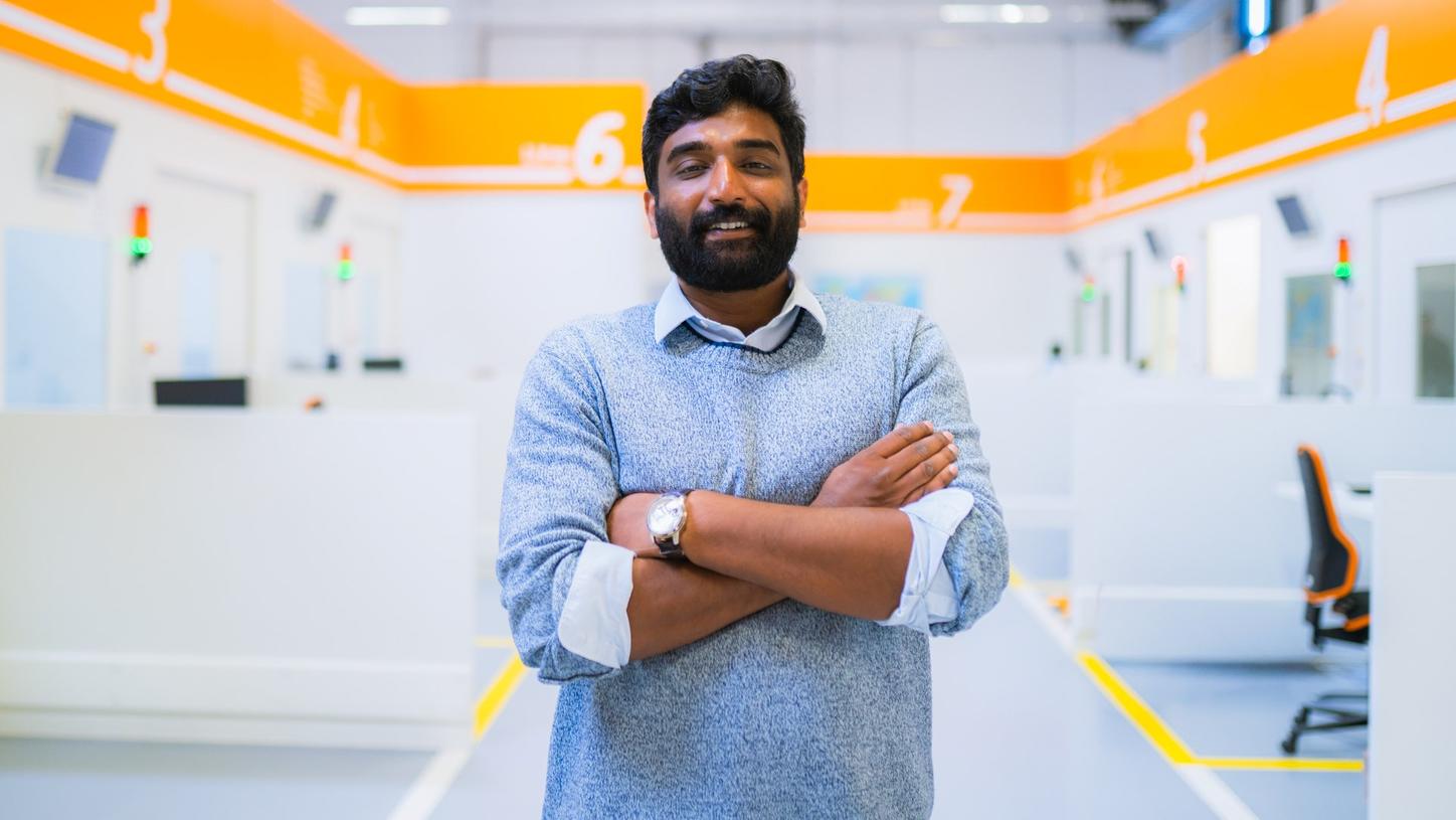Ullaskrishnan Poikavila stands with folded arms in a Siemens Healthineers production facility.