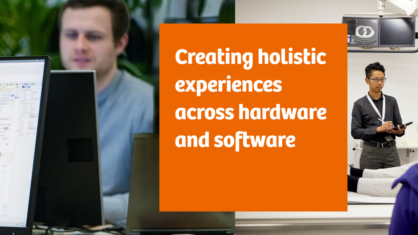White box with black text that says "Creating holistic experience across hardware and software" with two men in the background on either side.