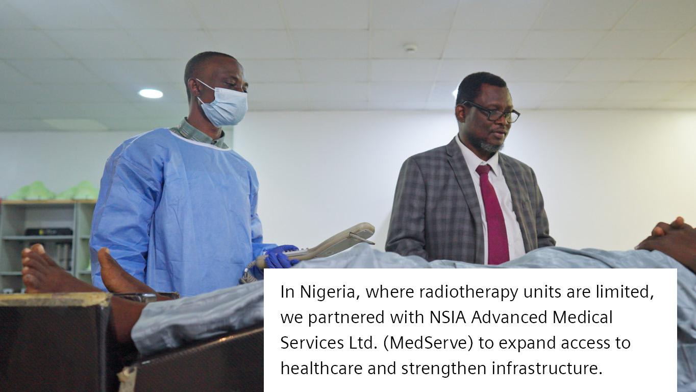 Medical staff sit in front of a screen in the scanning control room.