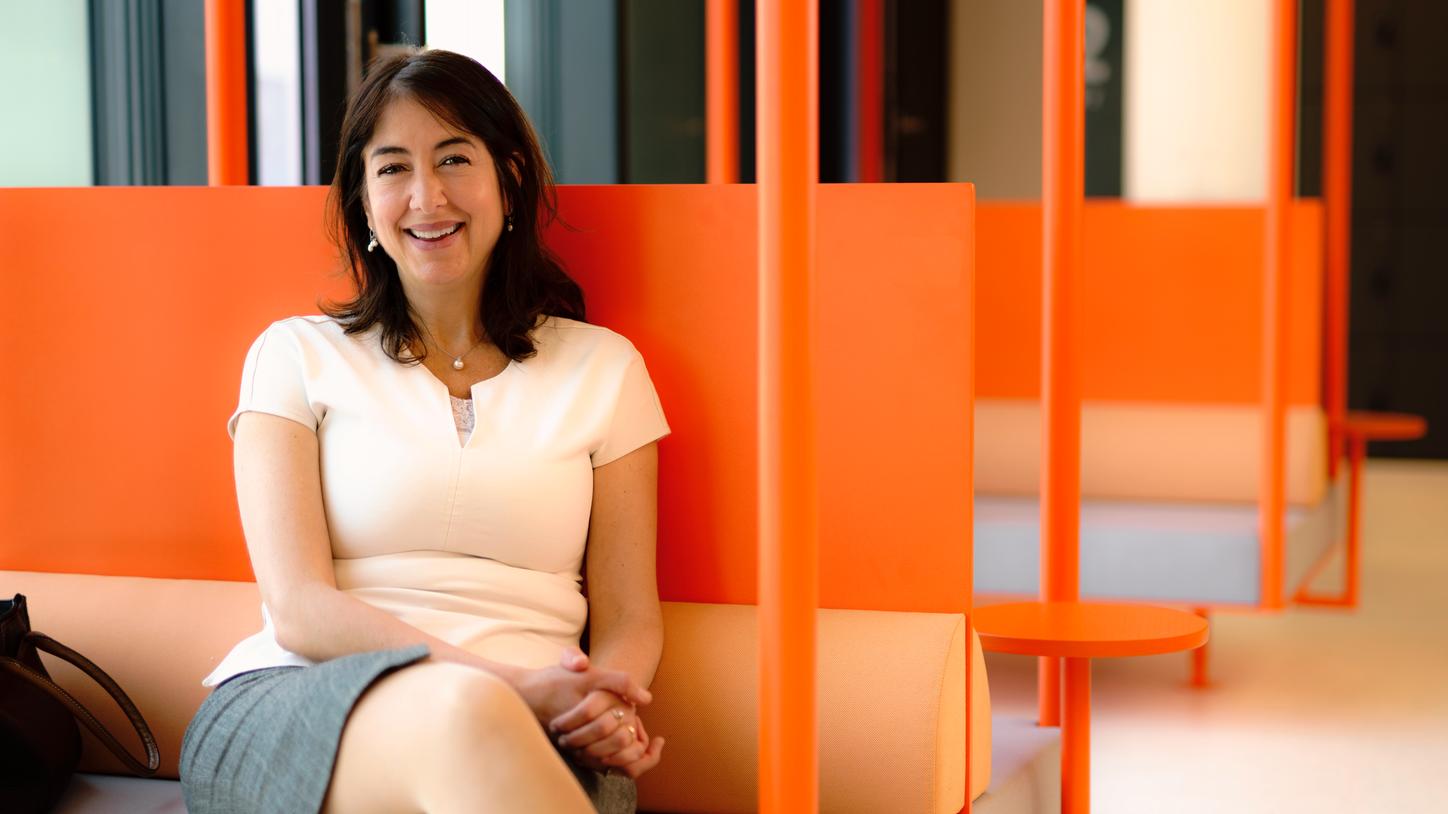 Elena Nioutsikou sitting on an orange bench and looking in the camera.