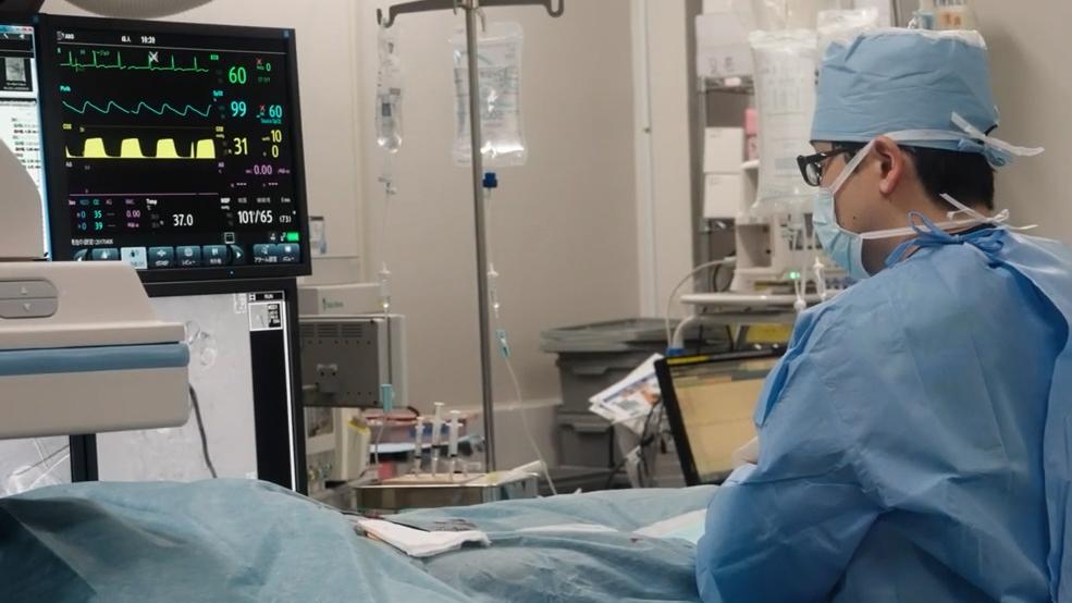 Surgeon watching real time imaging on a screen while performing minimally invasive surgery.