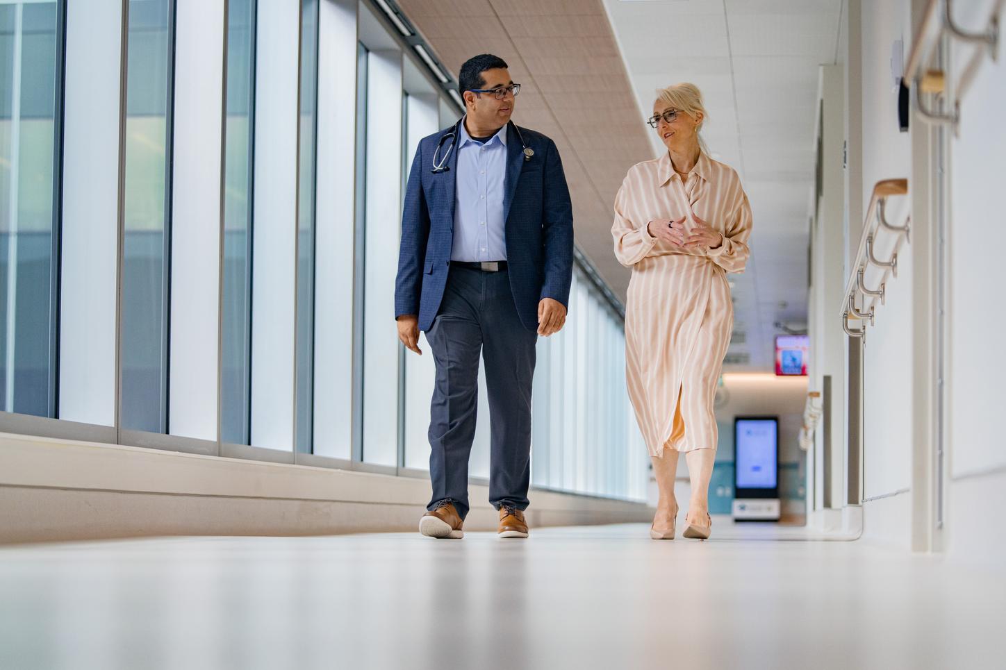 Omar Khan, MD, and Brenda Hubley walking through the cancer center