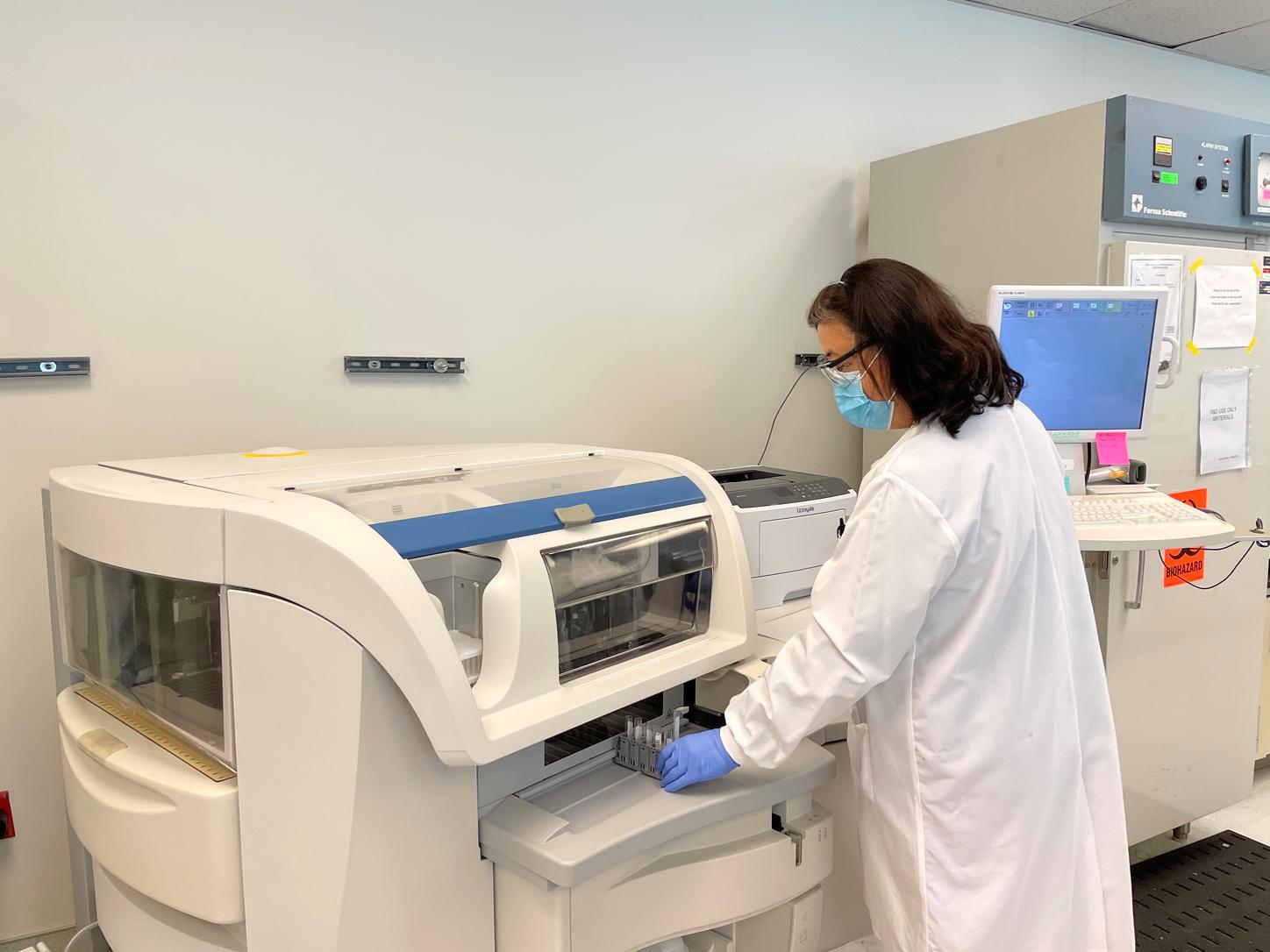 Interior views of the Center for Innovation in Diagnostics, run by Siemens Healthineers, with laboratorians working on the systems.