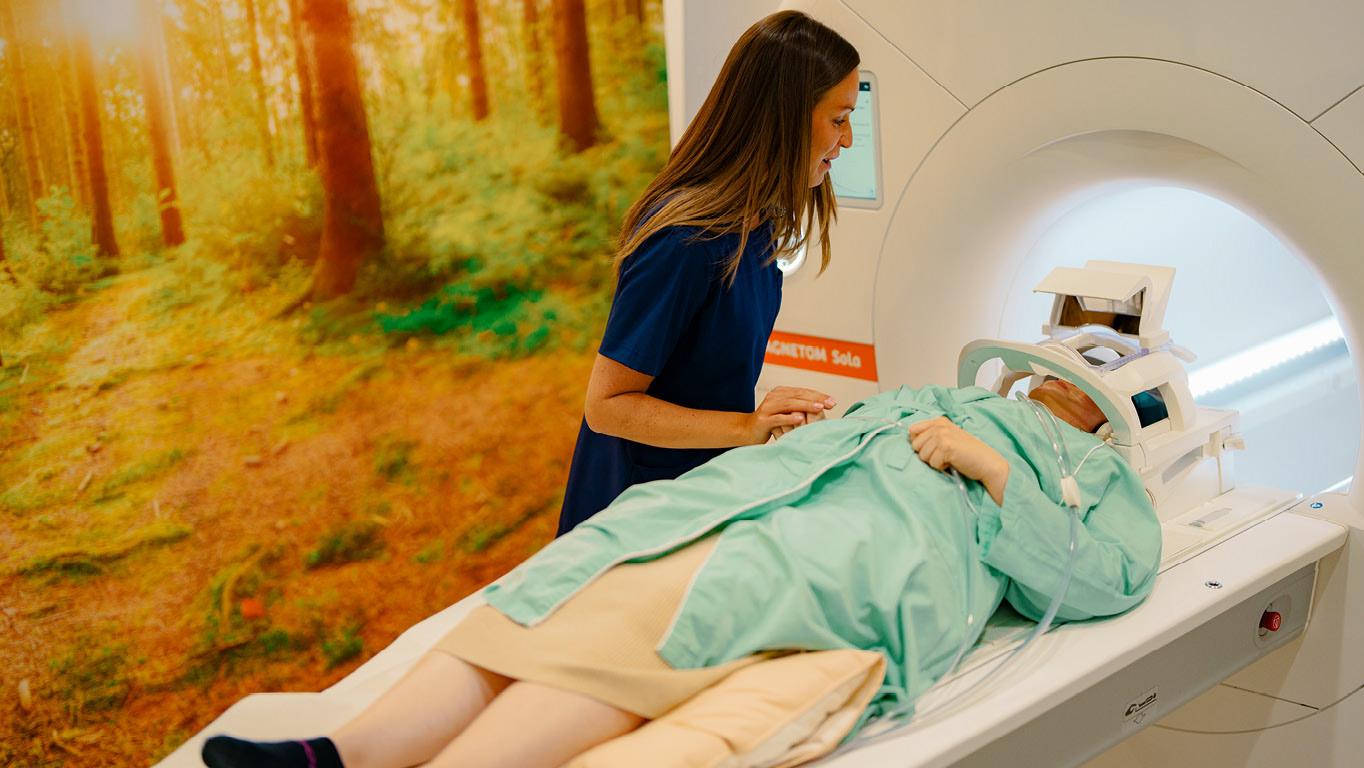 Medizinische Fachangestellte bereitet einen Patienten auf eine MRT-Untersuchung vor