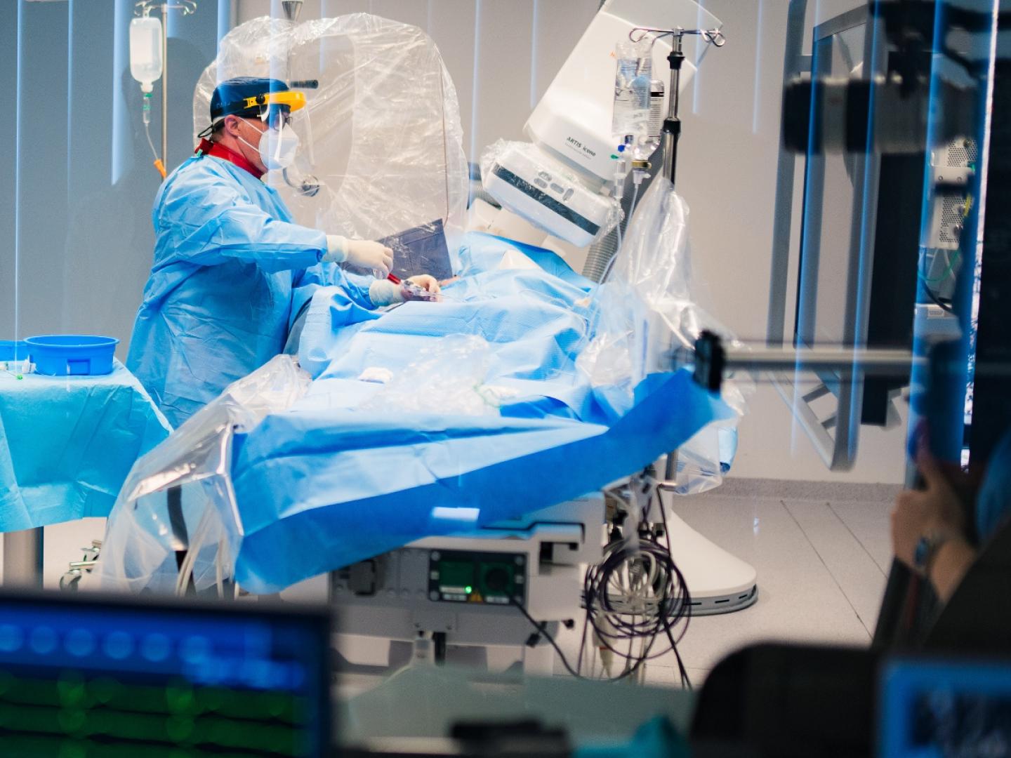 Healthcare professional performing a minimally invasive procedure in an interventional imaging suite. Part 2