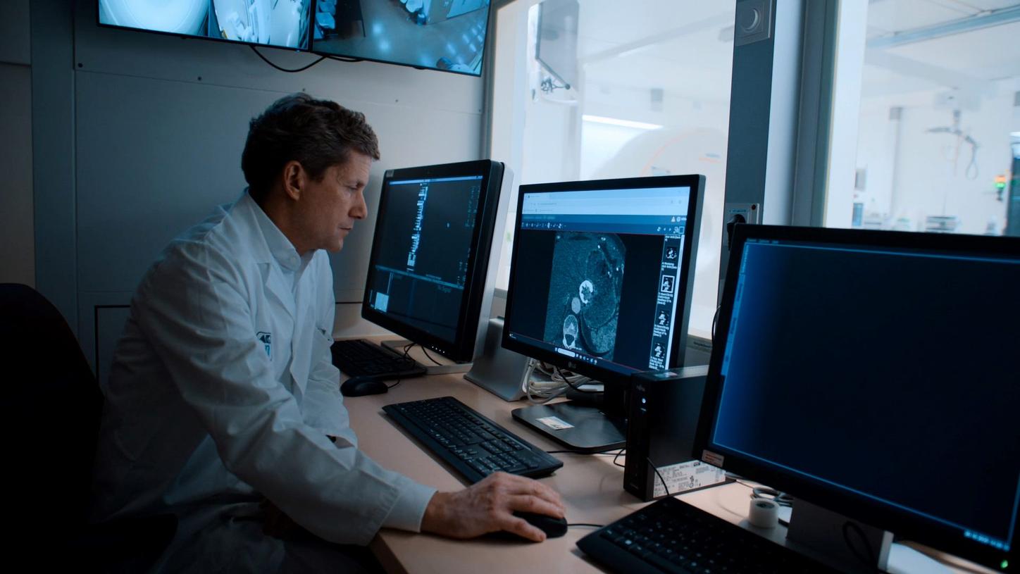 Image of a doctor siitng in front of screens