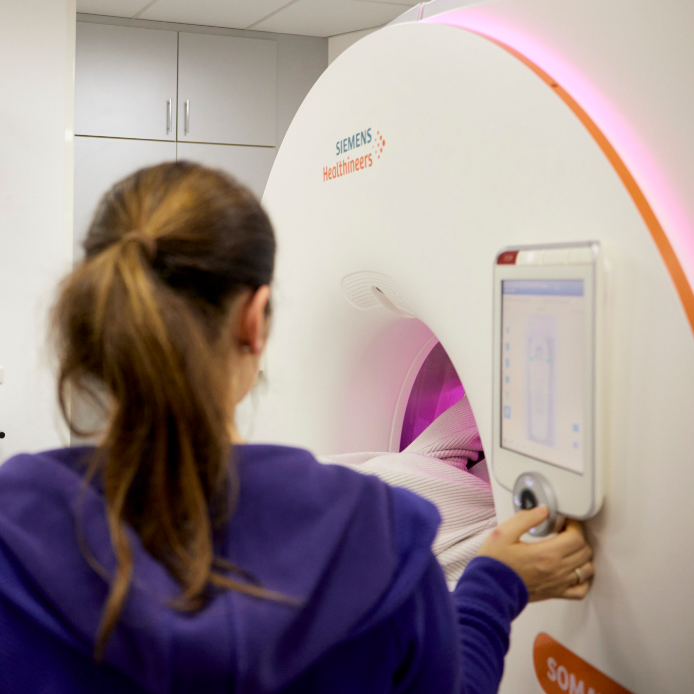 Frau, die eine Siemens Healthineers-Maschine bedient.