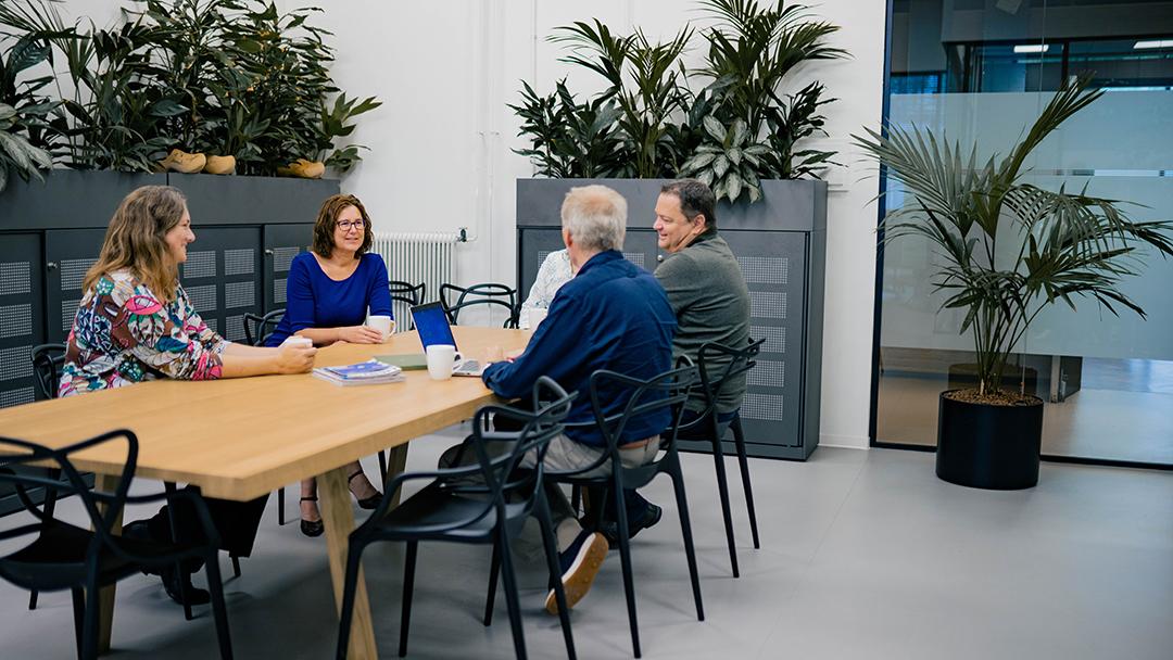 Femke and team sitting on the kitchen table, talking