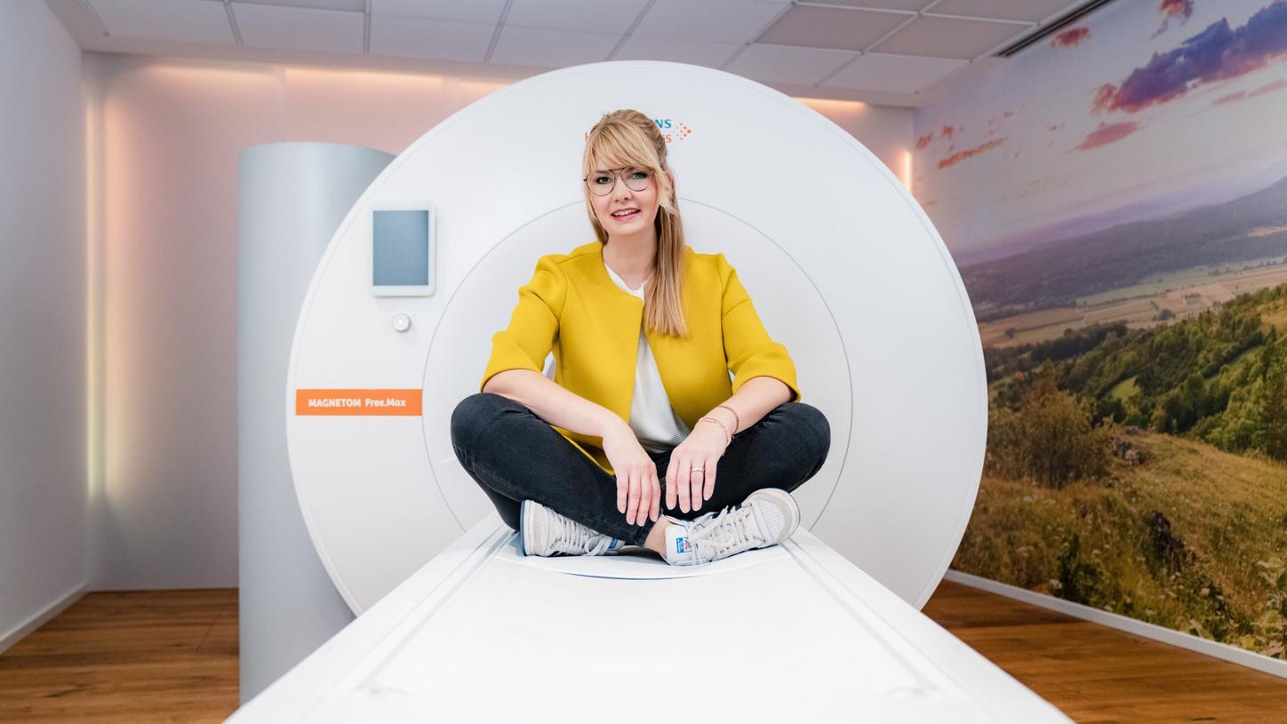 #Futureshaper: Stefanie sitting on the bed of an MR scanner 